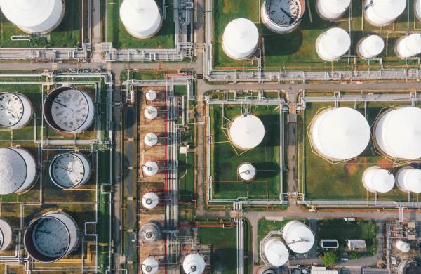 Aerial view morning time of petro chemical plant and oil refinery, power plant working with crude oil Storage tank at sunrise near mountain green environment concept