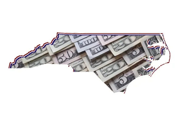 American dollar banknotes forming the map of North Carolina State and white background