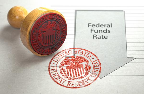Federal funds rate decrease. Arrow with cut of federal fund rate and stamp of federal reserve FRS symbol.