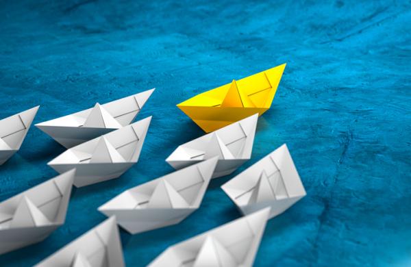 Leadership, success, and teamwork concept, yellow leader paper boat leading white followers boats. 3D Render