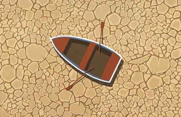 Abandoned rowboat stranded on dry, cracked land