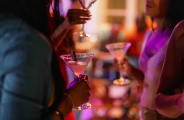 Close Up of A Martini Glass Held By A Female At A Bar