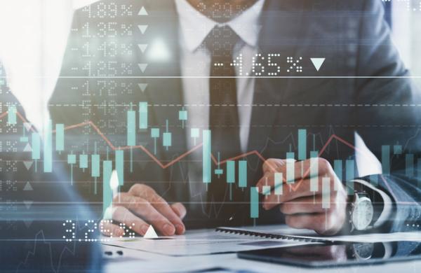 Digitally enhanced shot of a group of unrecognizable businesspeople meeting in the boardroom superimposed over a graph showing the ups and downs of the stock market