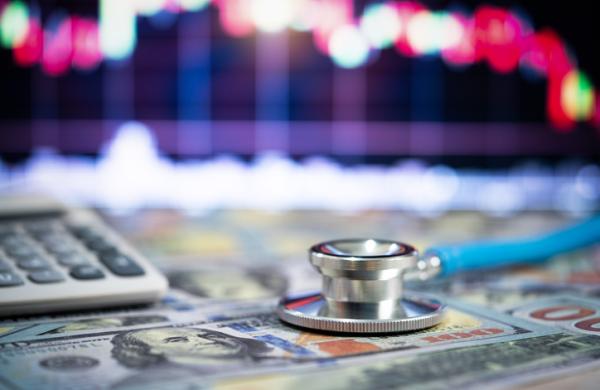 Stethoscope and money,Financial analysis, auditing or accounting - calculator calculators and dollar banknotes
