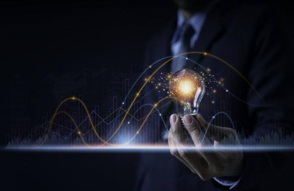 Businessman holding a light bulb showing ideas or investment planning, marketing strategy, has realistic graphs showing business growth