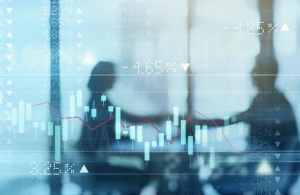 Digitally enhanced shot of a two businesspeople shaking hands in the boardroom superimposed over a graph showing the ups and downs of the stock market