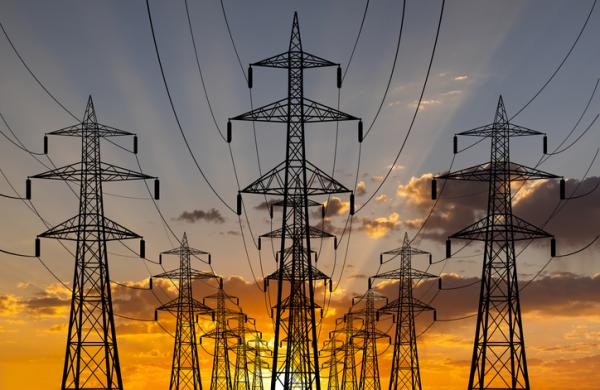 High voltage towers at sunset background. Power lines against the sky