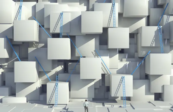 Caucasian man looking at blue ladders on cube wall