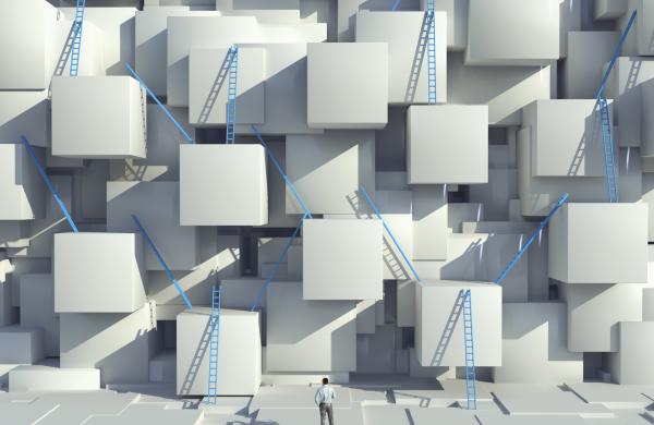 Caucasian man looking at blue ladders on cube wall