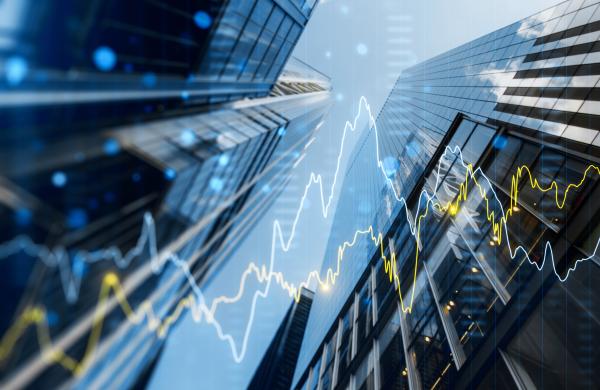A double exposure image of skyscrapers with overlay of financial graphs, set against a blurred background, illustrating the concept of business growth