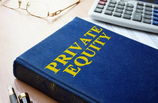 Book with title private equity and calculator.