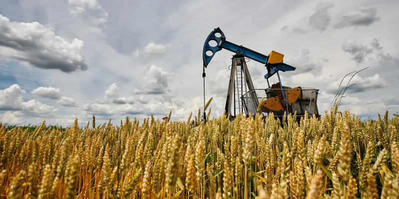 Oil pump in the wheat field, oil industry equipment