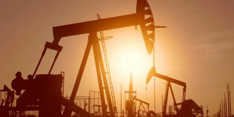 Oil pumpjack silhouetted against a sunset sky.