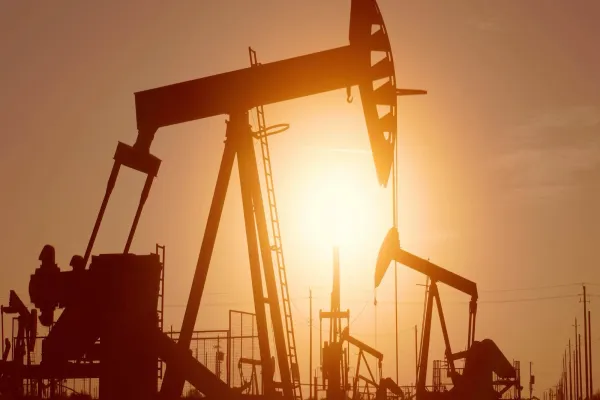 Oil pumpjack silhouetted against a sunset sky.