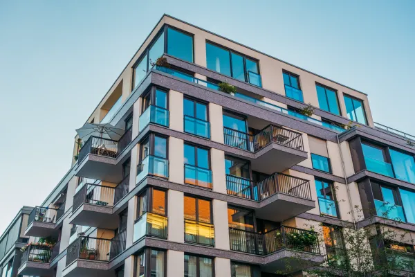Modern multi-story apartment building with blue accents and balconies.